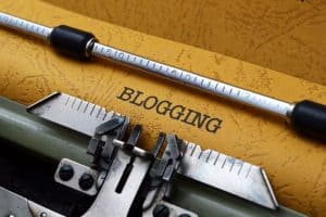 Close-up of a typewriter with "BLOGGING" written, emphasizing blog content creation.