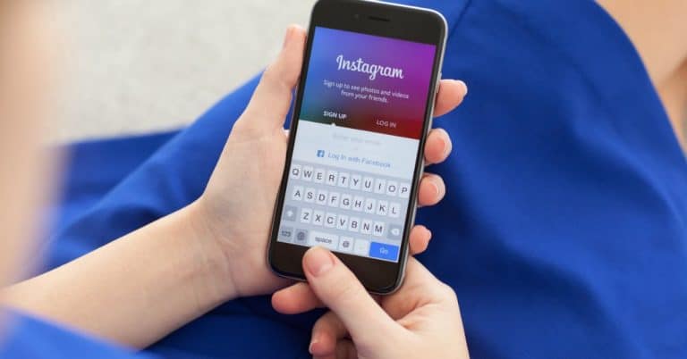 Person using smartphone to log into Instagram for social media marketing strategies.
