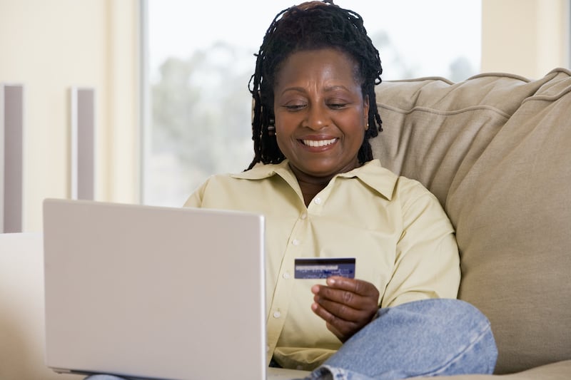 Woman shopping online with credit card on laptop for e-commerce success.
