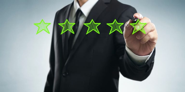 Business professional drawing a five-star review rating for client testimonials.