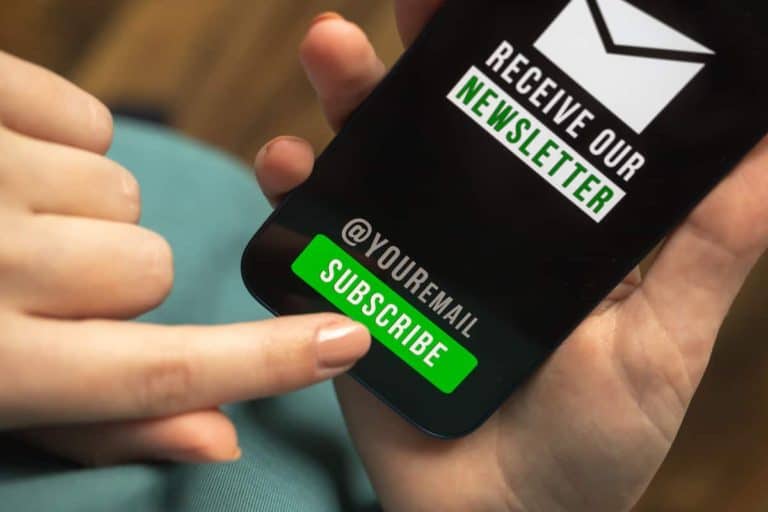 Mobile phone displaying newsletter sign-up with subscribe button.